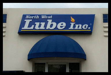 North West Lube illuminated building box sign shown during the day